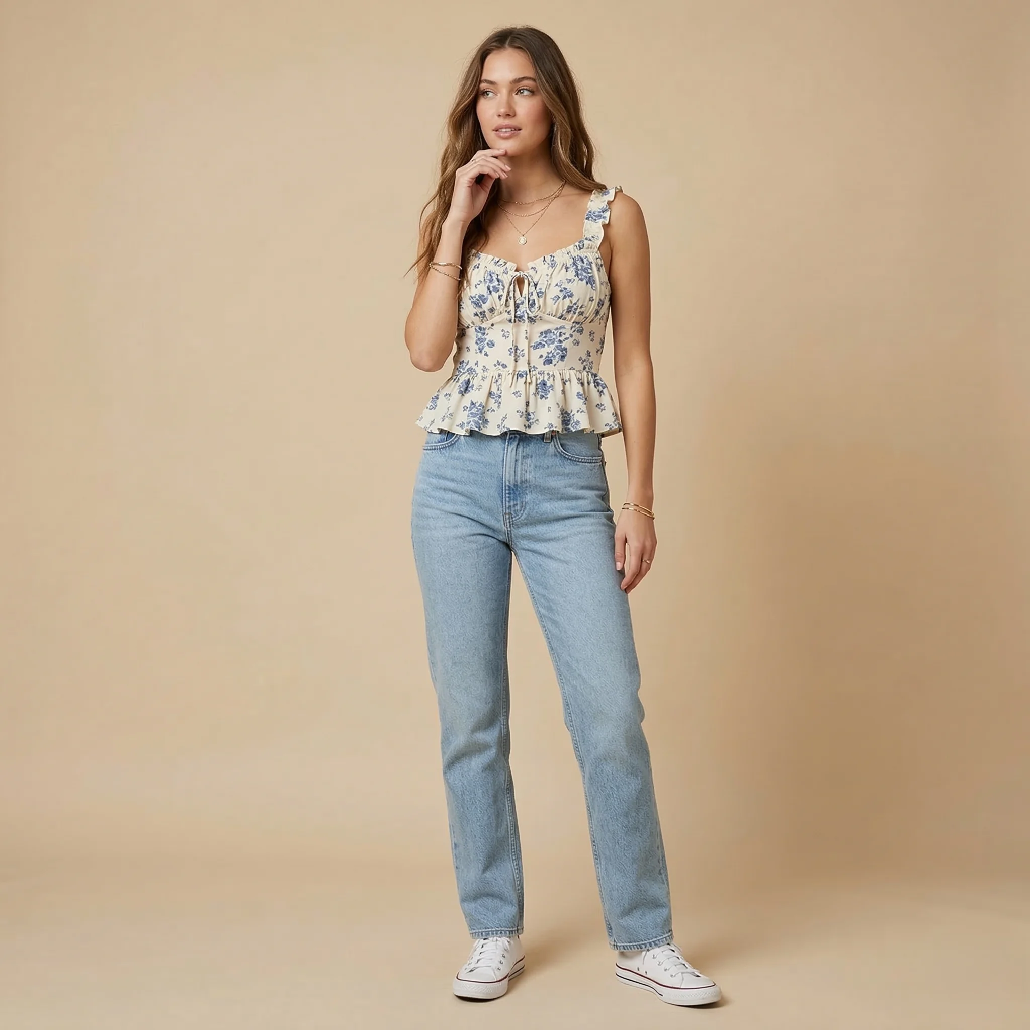 oman wearing a blue floral ruffle peplum top paired with light wash denim jeans and white sneakers.