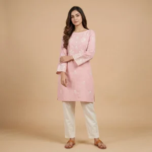 Woman wearing a pink embroidered cotton kurti with bell sleeves and white embroidered straight pants for an elegant ethnic look